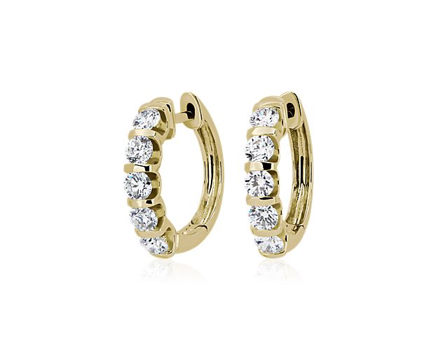 These eye-catching hoop earrings are crafted from luxurious 14k yellow gold and sparkle with 2 ct. tw. of round-cut diamonds set in ascending size along the front of the hoop. The gold design features bar accents between each stone for a dramatic art deco-inspired look.