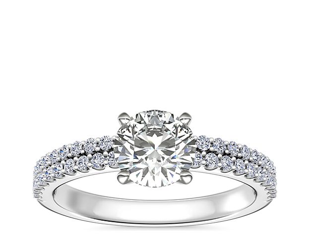 A symbol of timeless romance, this elegant engagement ring mesmerizes with dual rows of delicate diamonds shimmering brilliantly along the shank. The platinum design ensures an enduring luster and luxurious quality.