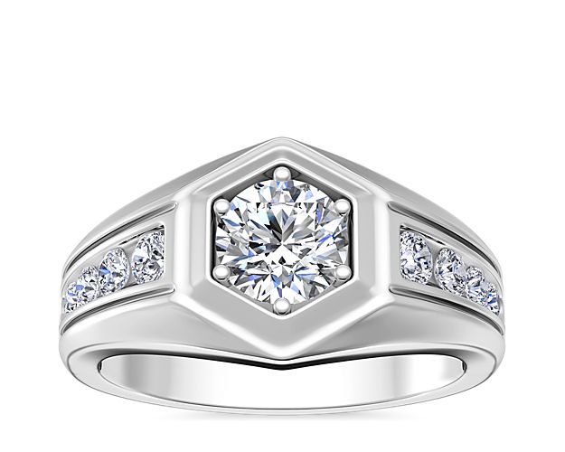 Symbolize lasting love with this 14k white gold engagement ring featuring a round-cut diamond nestled in an eye-catching hexagonal face. Channel-set diamonds sparkle brightly along the band for a stunning look as it catches the light.