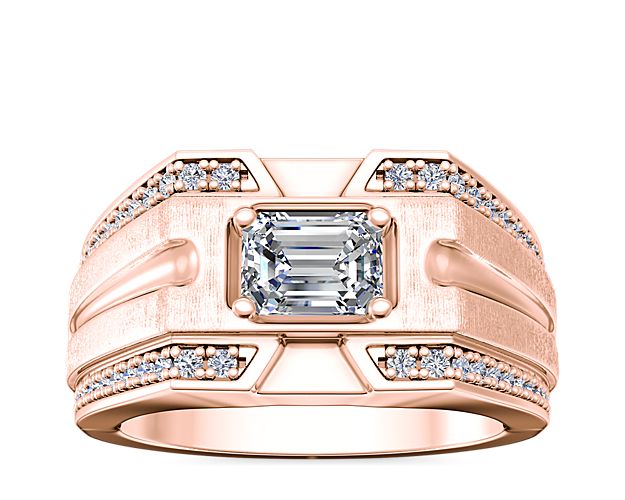 Brilliant channel-set diamonds sparkle along the outer edges of this beautifully grooved engagement ring crafted from 14k rose gold. The center shimmers with a stunning east-west set stone for an eye-catching effect.