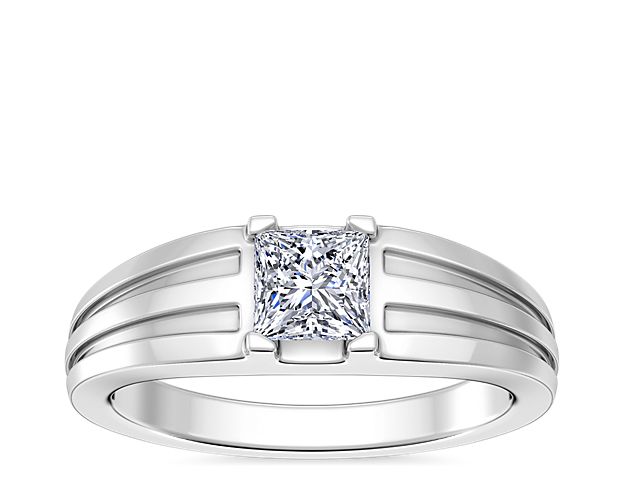 Love shines brilliantly from this engagement ring featuring an elegant center setting that  supports princess (prince), emerald-cut, and radiant-cut diamonds. The lustrous 14k white gold design features beautifully tapered and grooved stylings along the band.
