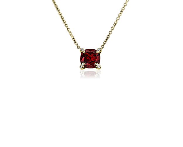 This simply elegant pendant features a deeply red garnet featuring a timeless cushion cut. It is beautifully set in lustrous 14k yellow gold, and features shimmering accent diamonds inlaid along the corner prongs.