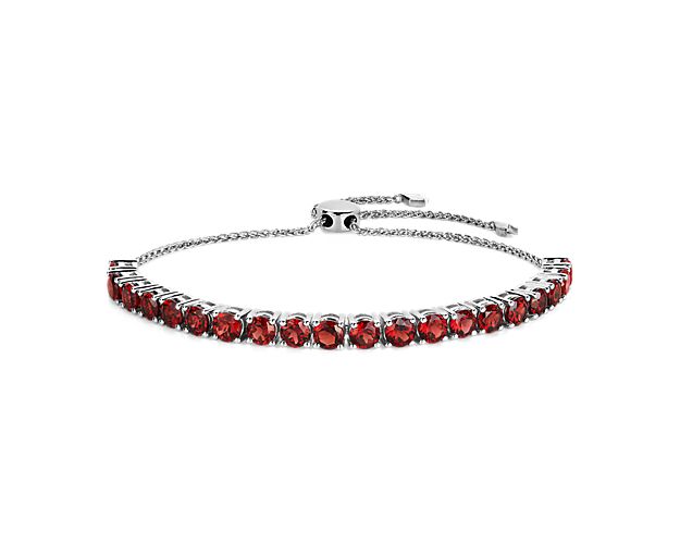 Crafted in sterling silver, this bracelet features round garnet stones with a bolo clasp. This bracelet is perfect for day or night.