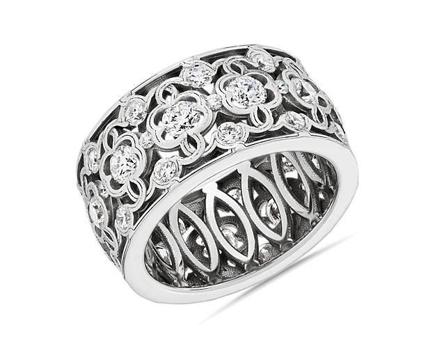 Proclaim romance with this mesmerizing eternity ring featuring a beautifully detailed clover lace pattern crafted from 18k white gold. It is intricately set with shimmering diamonds to capture the eye with plenty of sparkle.