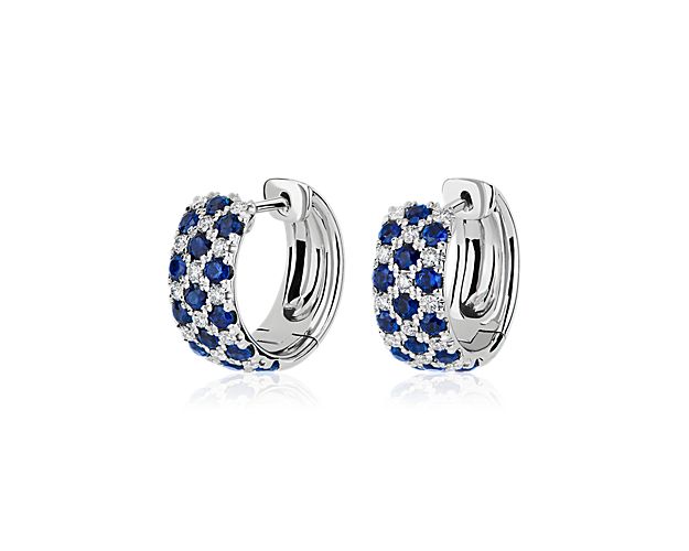 Catch the light in these bold hoop earrings featuring three rows of diamonds and sapphires alternating side-by-side. They feature brightly gleaming 14k design that promises lasting quality.