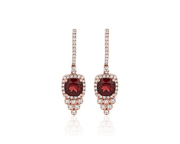 Crafted from luxurious 14k rose gold, these drop earrings feature rich red garnet stones dangling gracefully. A shimmering cascade of drop diamonds completes the elegant effect.