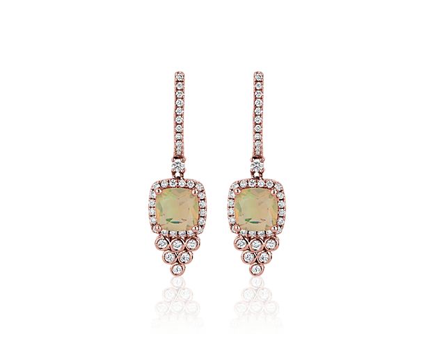 Stunning opals dangle gracefully from these drop earrings, highlighted by diamond drops sparkling below. They are set in warmly lustrous 14k rose gold to complete the eye-catching effect.
