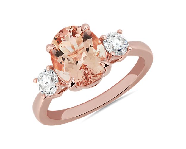 A dreamy oval-cut morganite stone nestles between two accent stones in this classic ring. It is beautifully crafted from gleaming 14k rose gold that complements the warmth of the centre stone.