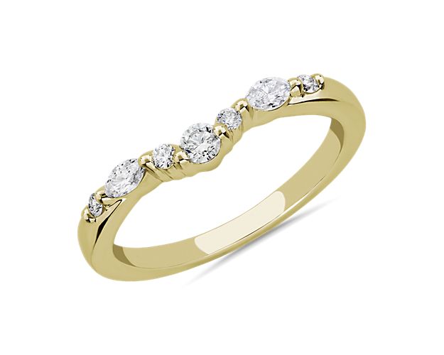 A symbol of beautiful love, this curved wedding ring is artfully crafted from 14k yellow gold, which promises a cool luster. A cluster of marquise-cut and round-cut diamonds add sparkle to match your engagement ring.
