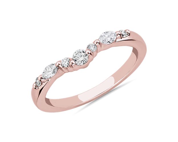 A symbol of beautiful love, this curved wedding ring is artfully crafted from 14k rose gold, which promises a cool luster. A cluster of marquise-cut and round-cut diamonds add sparkle to match your engagement ring.