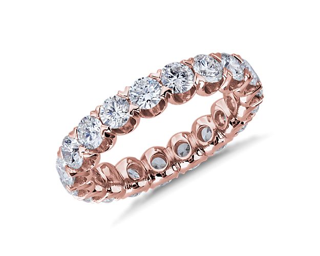 This gorgeously sparkling eternity ring features diamonds encircling it, each held gracefully in a stunning V-prong pavé setting. It is made of luxuriously lustrous 14k white gold that promises lasting quality.