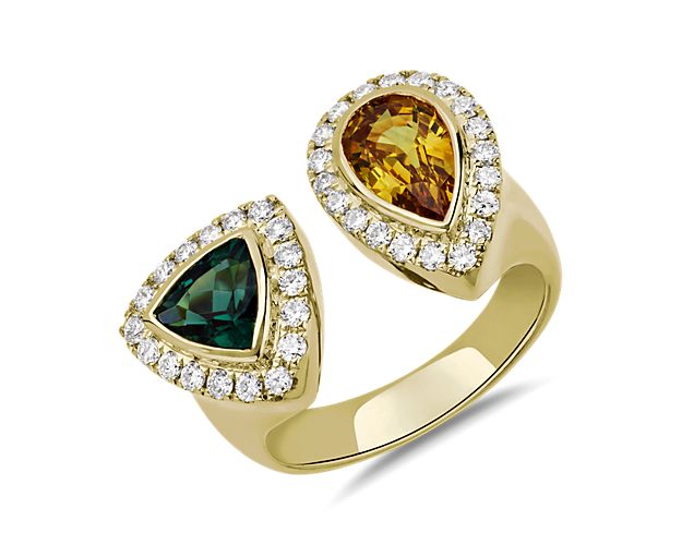 Set in 18k yellow gold, this ring features a pear shaped yellow sapphire ring and a trillion cut green tourmaline gemstone surrounded by brilliantly sparkling diamonds.