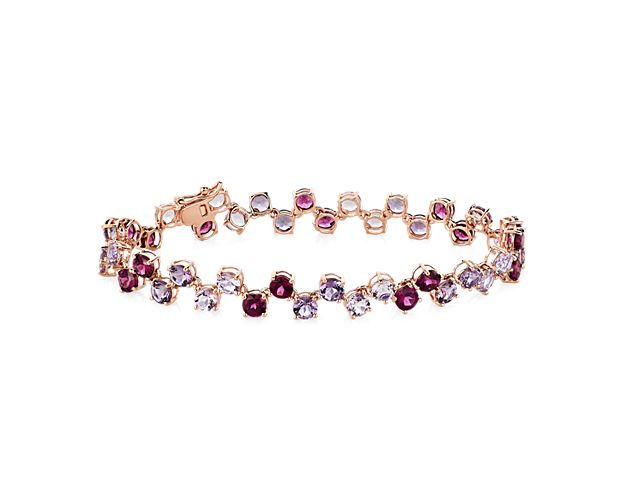 This bracelet features a delicate pattern of round-cut rhodolite and amethyst stones sparkling along its length. The intricate design is beautifully crafted in lustrous 14k rose gold.