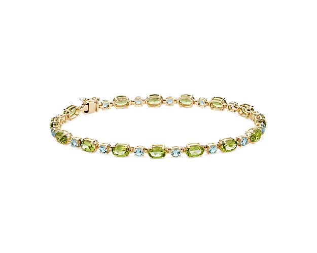Oval-cut peridot stones alternate beautifully with round-cut sky blue topaz stones in this breath-taking bracelet. Gleaming 14k yellow gold design brings a beautiful finish to this piece.