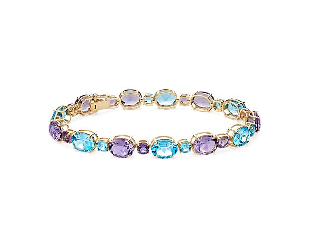 Bright and brilliant, the vivid oval- and cushion-cut amethyst and Swiss blue topaz stones sparkle along the length of this unique bracelet. It boasts luxe 14k yellow gold design to complete the style.