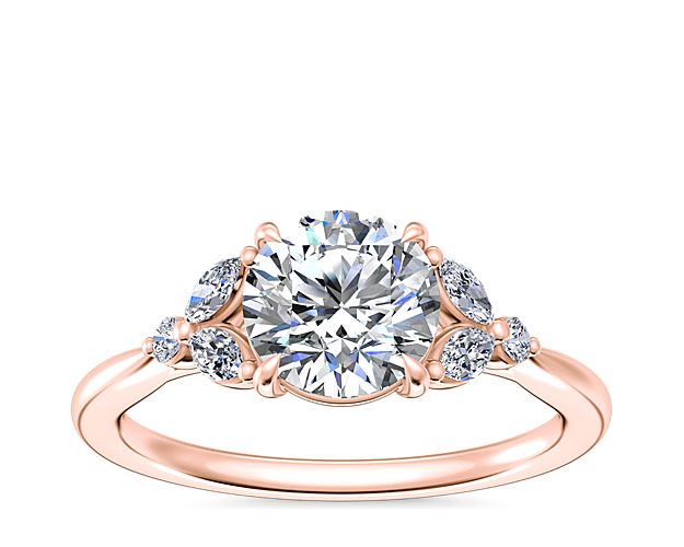 This elegant engagement ring embodies romance, with a floral-inspired design featuring marquise-cut diamonds gracefully framing the center stone. The warm beauty of the 14k rose gold's luster gives it a dreamy look.
