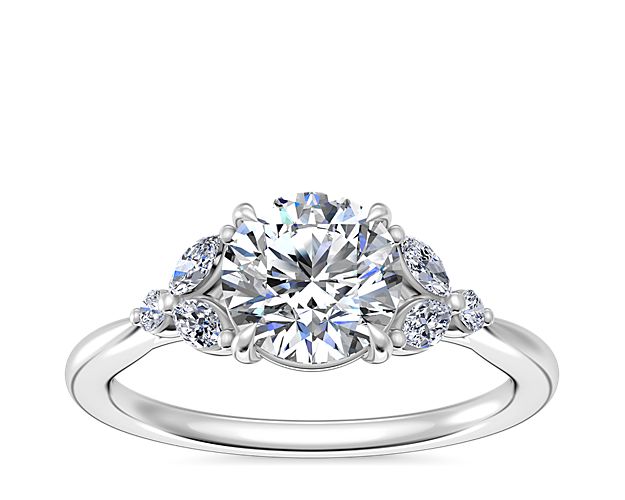 Inspire dreams of romance with this engagement ring crafted from luxurious platinum that boasts an enduring luster. The center stone is beautifully surrounded by marquise-cut diamonds that contribute breathtaking sparkle and a floral-inspired look.