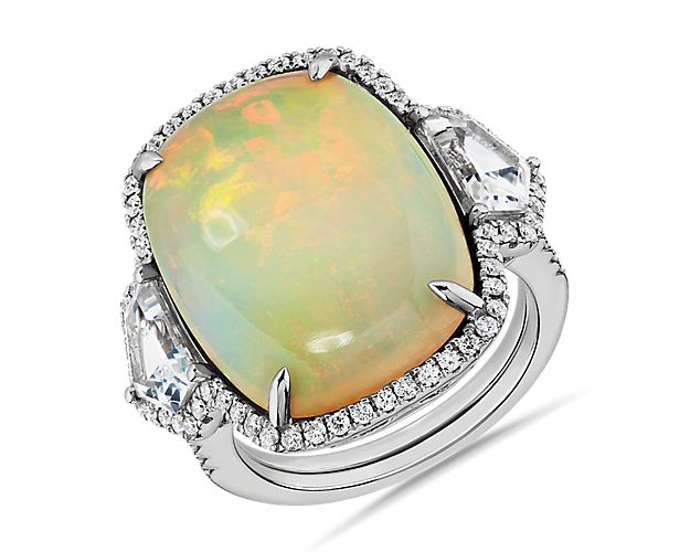 Indulge in bold luxury as you slip on this ring featuring a statement long cushion-cut opal framed by two Cadillac-cut white sapphires at the sides. The 18k white gold design promises a bright, enduring luster.