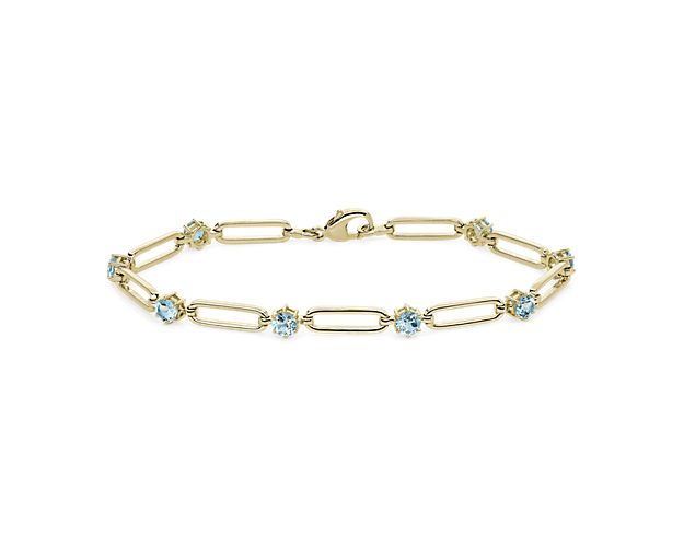 Gorgeous sky blue topaz stones sparkle between each paper clip link of this beautiful bracelet, giving it a touch of eye-catching color. The luxuriously gleaming 14k yellow gold design beautifully complements the cool tones of the stones.