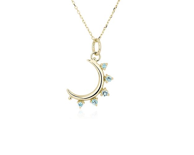 This elegant crescent moon-shaped charm and the matching chain are beautifully crafted from lustrous 18k yellow gold. Brilliant blue topaz stones shimmer along the edge of the moon.