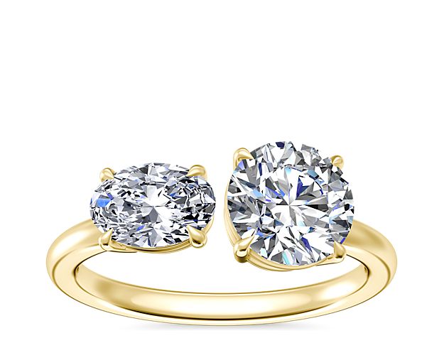 Love sparkles brilliantly from this engagement ring featuring a dual-stone design made of lustrous 14k yellow gold. Your choice of round, princess, pear, asscher, emerald-cut, radiant, cushion, marquise, or oval stone is beautifully matched by a shimmering east-west oval-cut diamond.
