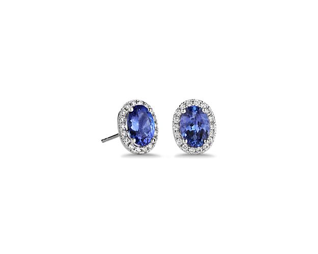 Go for a timelessly elegant look when you wear these classic white gold stud earrings set with deep blue oval-cut tanzanite stones. Delicate diaond halos surround the centre stones with brilliant sparkle.
