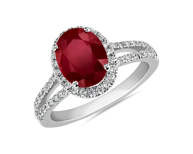 Exude elegance as you wear this stunning ring featuring a dramatically red oval-cut ruby at its heart. Brilliant diamonds accentuate it with a sparkling halo and add shimmer to the split shanks.