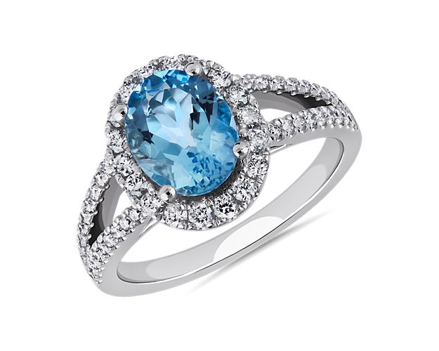 A brilliantly blue oval-cut aquamarine sparkles at the heart of this statement ring. Bright accent diamonds form an elegant halo around the center stone and add brilliance to the graceful split shank.