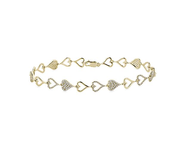 Add a touch of romance to your wrist with this gleaming bracelet featuring lustrous 14k yellow gold design. It features an alternating heart pattern, with gleaming hollow gold hearts alternating with hollow and solid gold hearts featuring pavé-set diamonds for brilliant sparkle.