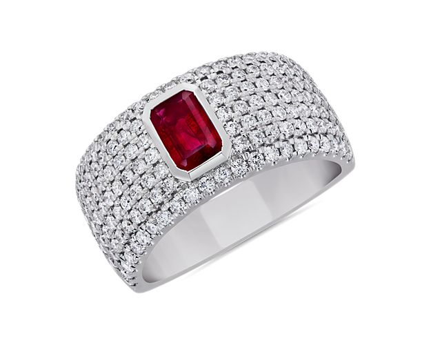 A bold emerald-cut deep red ruby sparkles at the heart of this ring, surrounded by beautifully delicate pavé-set diamonds. The wide platinum design promises lasting lustre and quality.