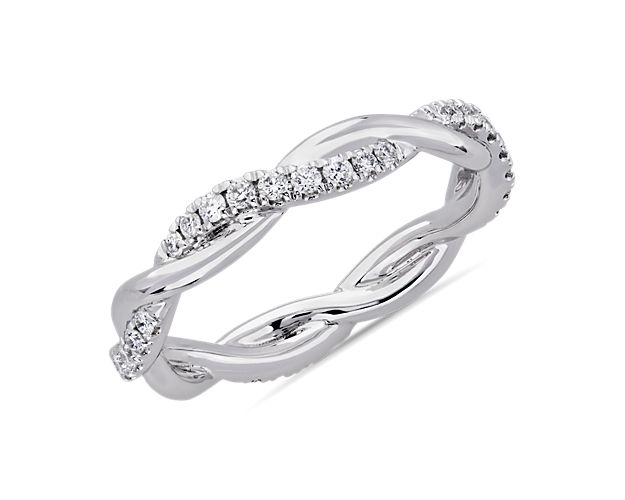 This beautiful and delicate wedding ring is formed by two intertwining bands, one of micropavé set diamonds and one of solid 14k white gold for an elegant statement.