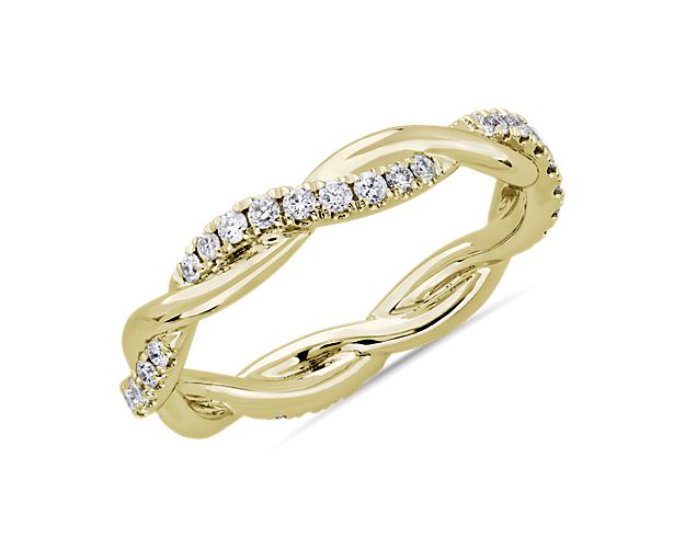 This beautiful and delicate wedding ring is formed by two intertwining bands, one of micropavé set diamonds and one of solid 14k yellow gold for an elegant statement.