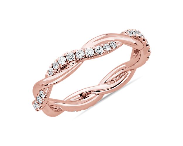 This beautiful and delicate wedding ring is formed by two intertwining bands, one of micropavé set diamonds and one of solid 14k rose gold for an elegant statement.