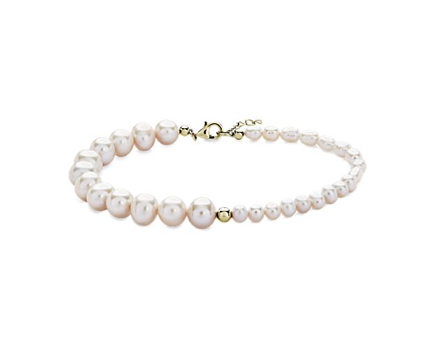 This beautifully crafted bracelet set in 14k yellow gold features a contrasting half-and-half look.  Small and large pearls separated by a polished gold bead elevate the classic pearl bracelet making it a versatile choice.