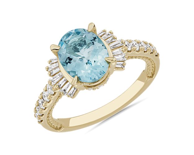 An oval-cut aquamarine commands attention to this stunning ring featuring bright 14k yellow gold design. A fan of accent diamonds add dramatic sparkle, and pavé-set diamonds trail down the shank for luxurious effect.