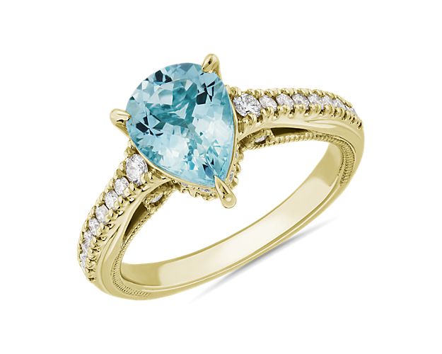 This ring's center aquamarine stone catches the eye with its dreamy blue hue and graceful pear cut. Stunning pavé-set diamonds add brilliance to the 14k yellow gold design for a luxurious finish.