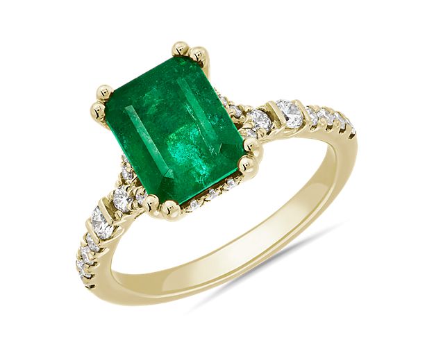 Opt for show stopping elegance with this ring boasting a statement emerald-cut emerald that flaunts its dramatic green hue as it is framed by shimmering accent diamonds. The eye-catching gleam of the 14k yellow gold design gorgeously complements the emerald's color.