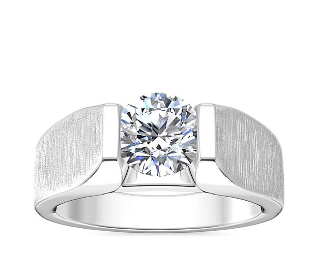 A shimmering tension-style diamond setting adds beautiful sparkle to this handsome men's engagement ring. The polished platinum promises a luxurious gleam and timeless quality.