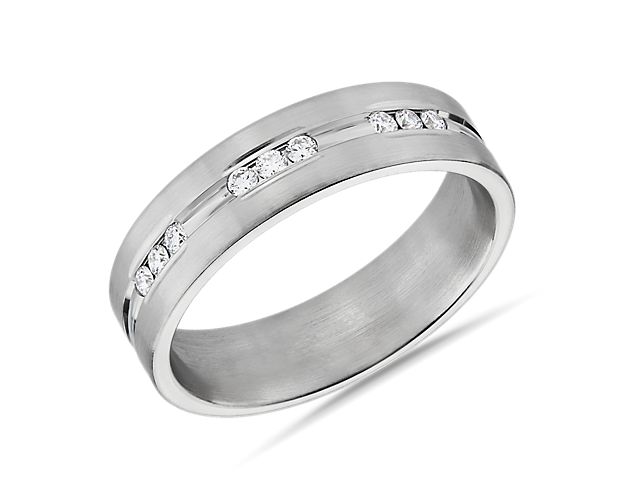Diamonds gather in threes on this 14k white gold wedding band that has a center groove laid with channel-set stones.
