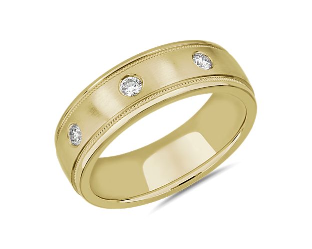 Intricate milgrain detail frames the edge of this wedding band with vintage-inspired charm, while bright diamonds sparkle along the centre. It is crafted from luxurious 14k yellow gold with a burnished finish.