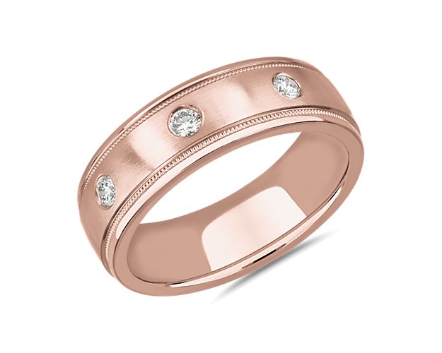 Intricate milgrain detail frames the edge of this wedding band with vintage-inspired charm, while bright diamonds sparkle along the centre. It is crafted from luxurious 14k rose gold with a burnished finish.