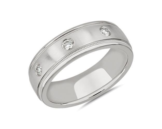 Intricate milgrain detail frames the edge of this wedding band with vintage-inspired charm, while bright diamonds sparkle along the centre. It is crafted from luxurious platinum with a burnished finish.