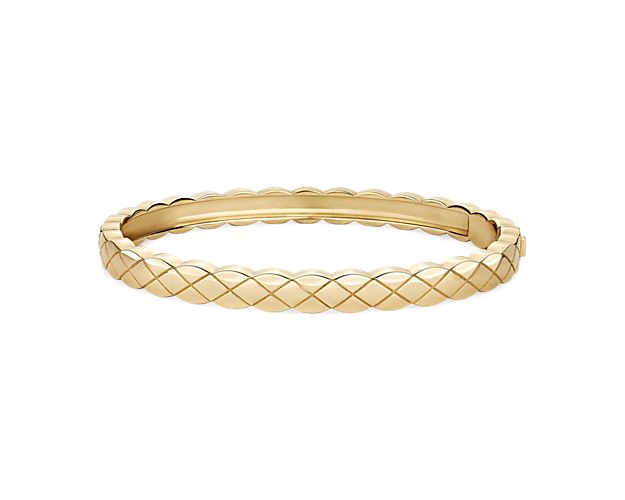 This bangle, crafted in 14k yellow gold, features a quilted design that goes all the way around this beautiful bracelet.