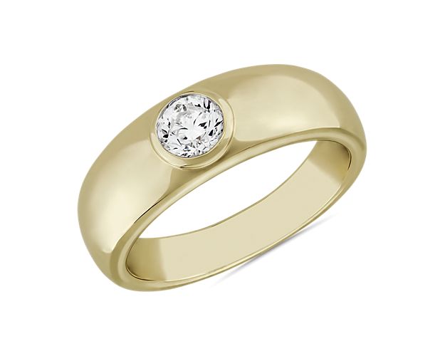 Flawless style you can hold onto forever defines this 14k yellow gold ring set with a single round diamond at its center as a declaration of its universal design. This ring has a low profile with a partially raised bezel and slightly tapered silhouette for comfort.