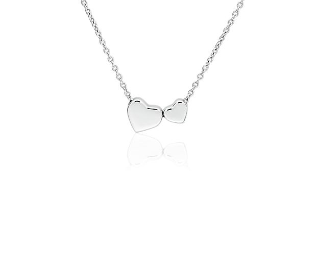 This delicate and sweet pendant, with its two nesting hearts, is a perfect symbol of love. This necklace is crafted in sterling silver and fastened on an 18 inch cable chain.