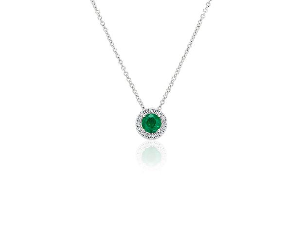 Capture your ray of starlight when layering on this striking 14k white gold pendant necklace. Its perfectly round emerald baths in the light of a white diamond halo creating a beautiful interplay of sparkle and color.
