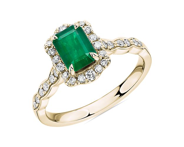This beautiful emerald is paired with 14k yellow gold and encased in a diamond halo for a unique and romantic look.
