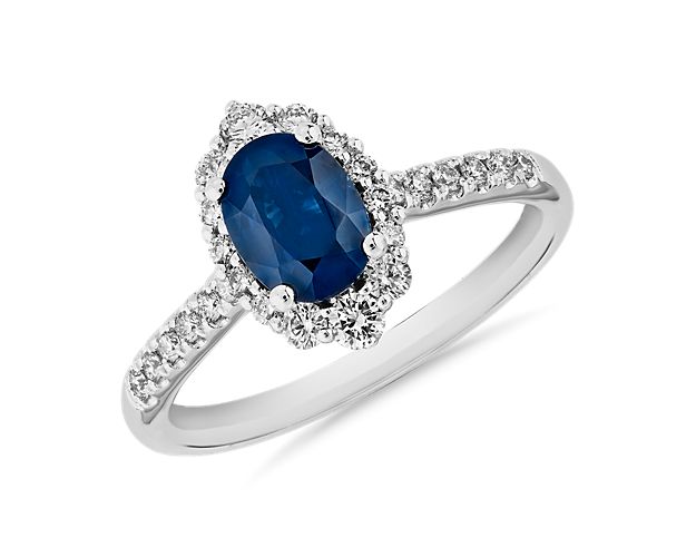 Timeless but chic, this elegant sapphire gemstone ring is adorned with diamonds down the sides, framed in 14k white gold.