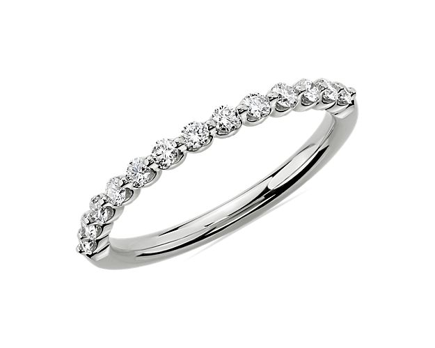 Featuring 13 hand-set floating diamonds sparkling along the lustrous platinum band, this wedding ring promises classic glamour as it represents timeless love.