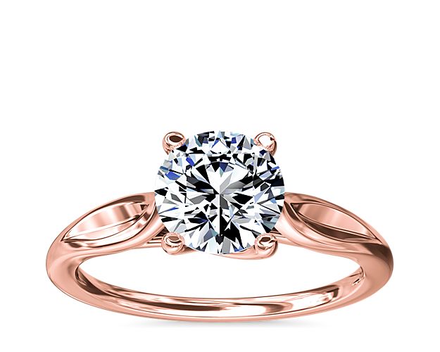 Inspired by the simple beauty of nature, this elegant solitaire engagement ring features leaf-shaped shanks that entwine gracefully around the center stone. Crafted from 14k rose gold, it promises a romantic warm luster that endures.